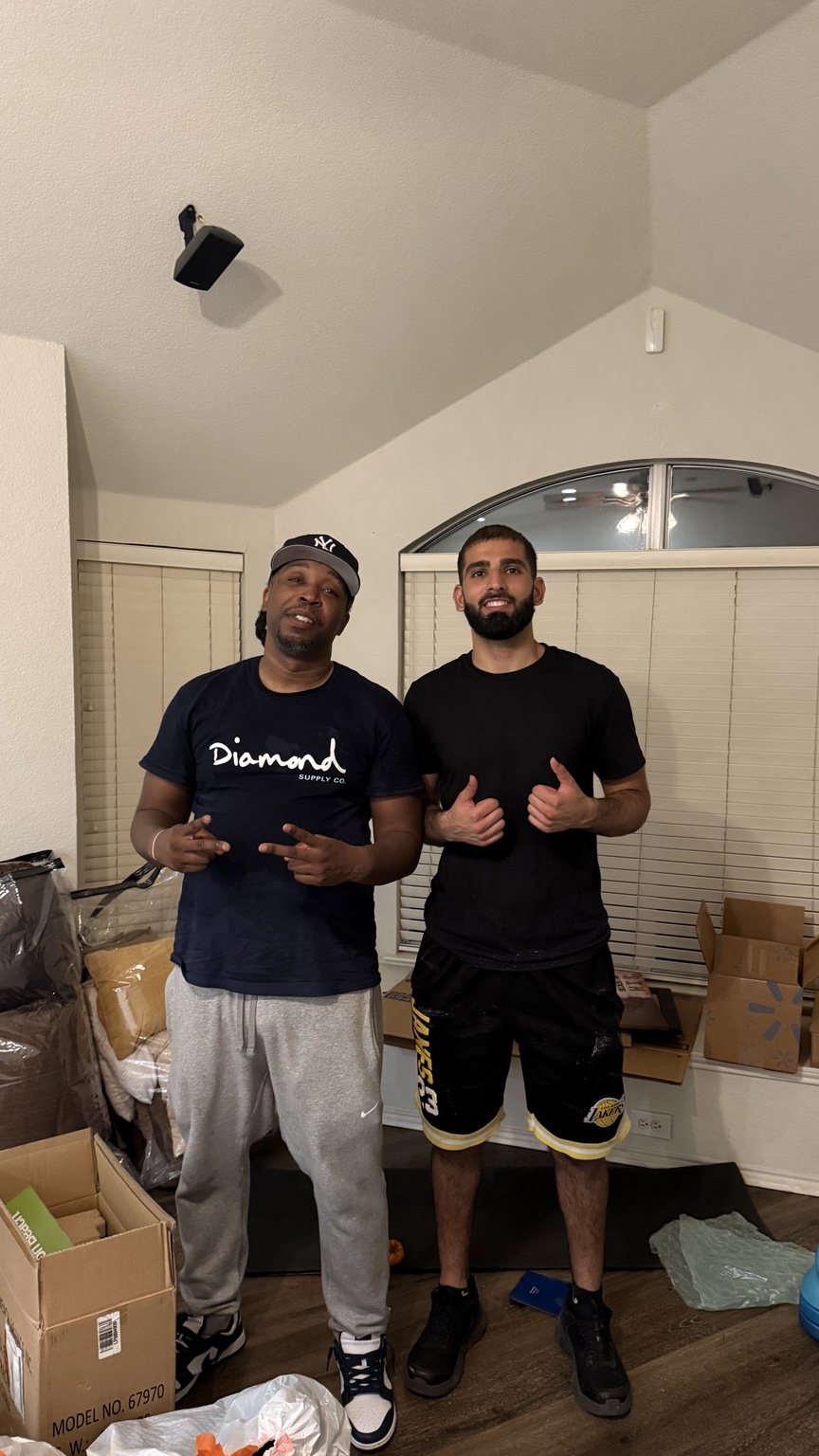 A Nahas Moving mover standing with a customer inside a home surrounded by boxes during a move